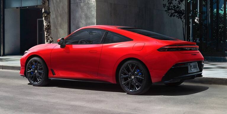2027 Honda Prelude in Rallye Red, 3/4 rear view, parked alone the street in the down town (exhilarating hybrid coupe).