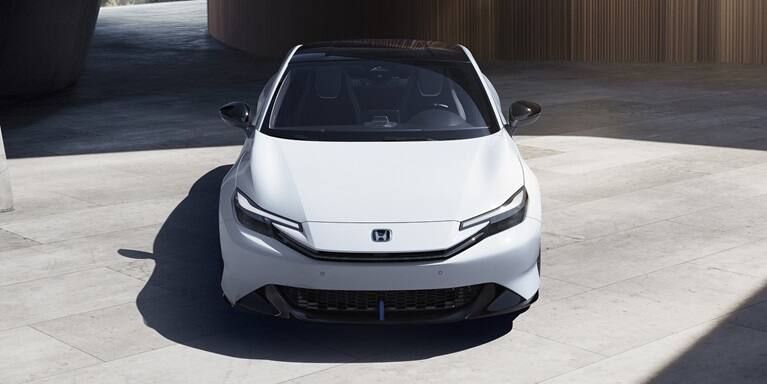 2027 Honda Prelude in Winter Frost Pearl, front overhead view with modern structure on the background (exhilarating hybrid coupe).
